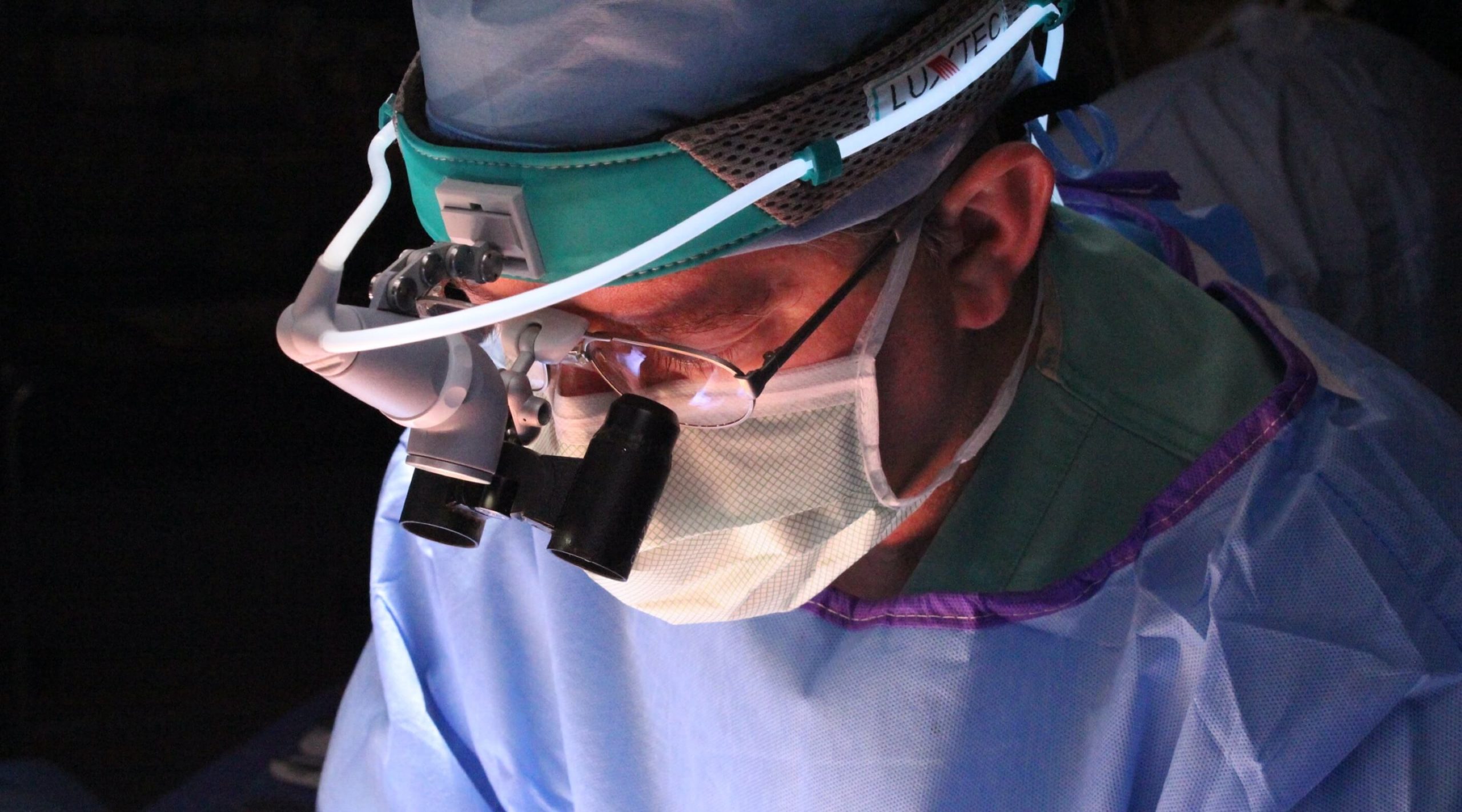 Doctor performing surgery using glasses attached scopes