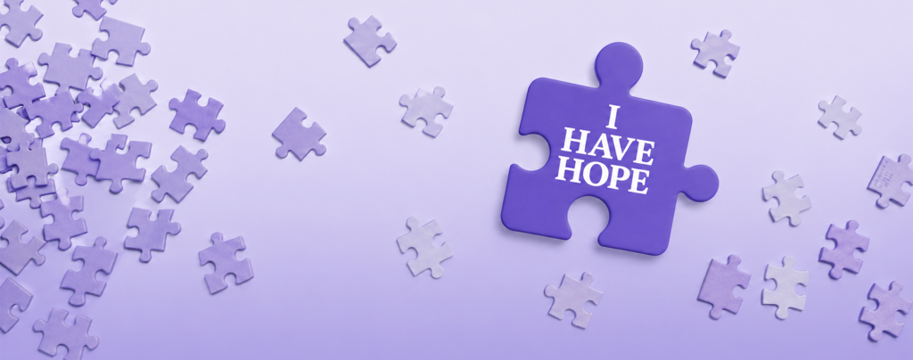 Purple puzzle piece with the words I Have Hope surrounded by floating puzzle pieces on a soft lavender background.